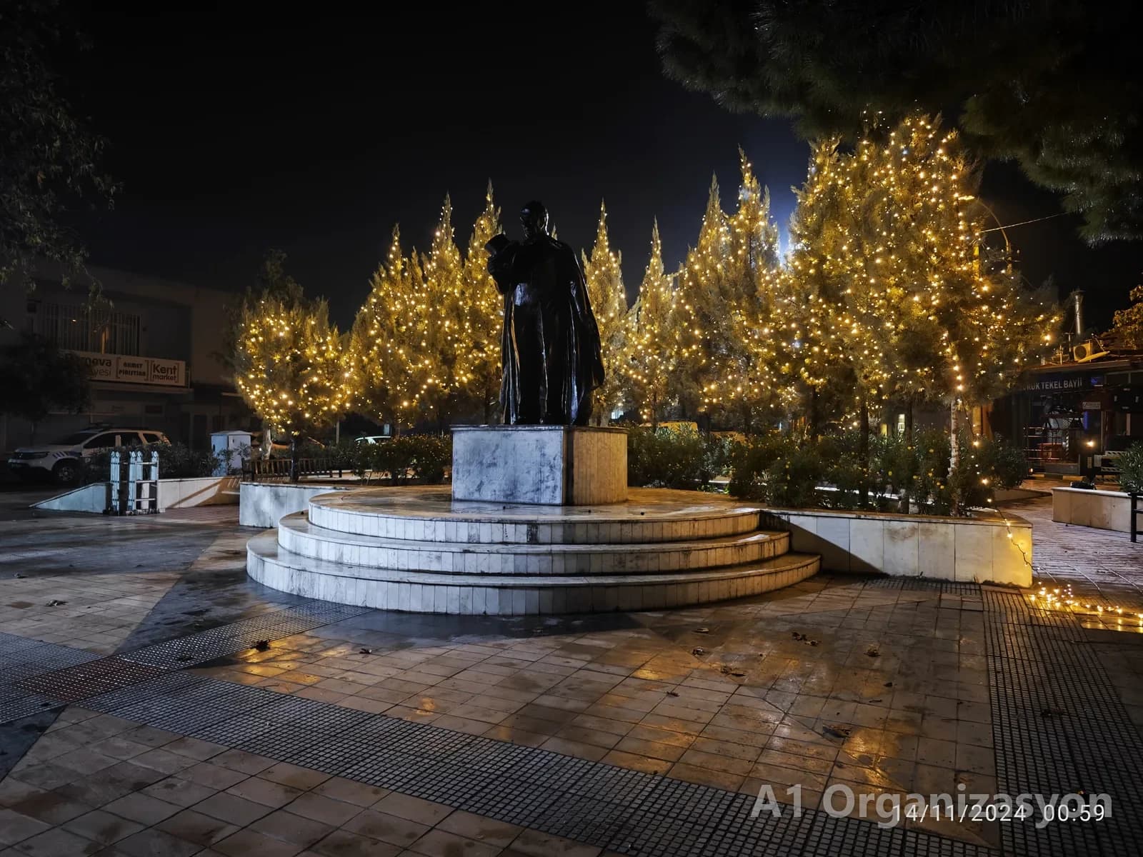 Meydandaki ağaçlar ip LED ile sarılmış, ortada heykel, gece - A1 Organizasyon